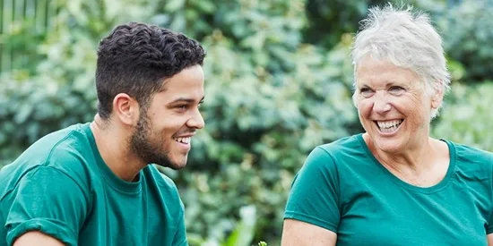 A younger man and older woman sitting and laughing together