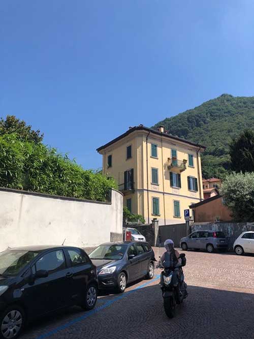 A street scene in Milan with a building in the background and blue sky