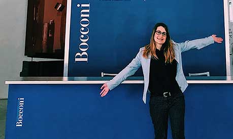 Camille Hanotte standing in front of the Bocconi logo