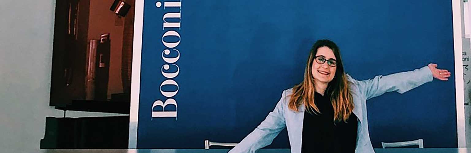 Camille Hanotte standing in front of the Bocconi logo