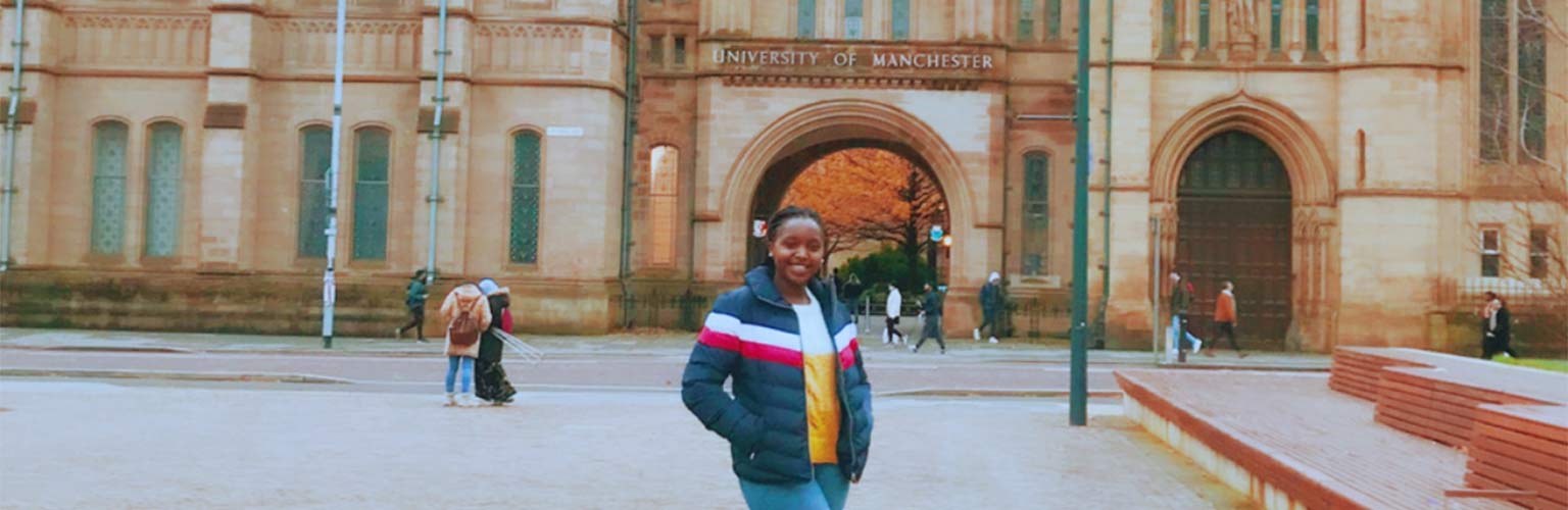 Emerance Mutesi at Brunswick Park with The University of Manchester in the background. 