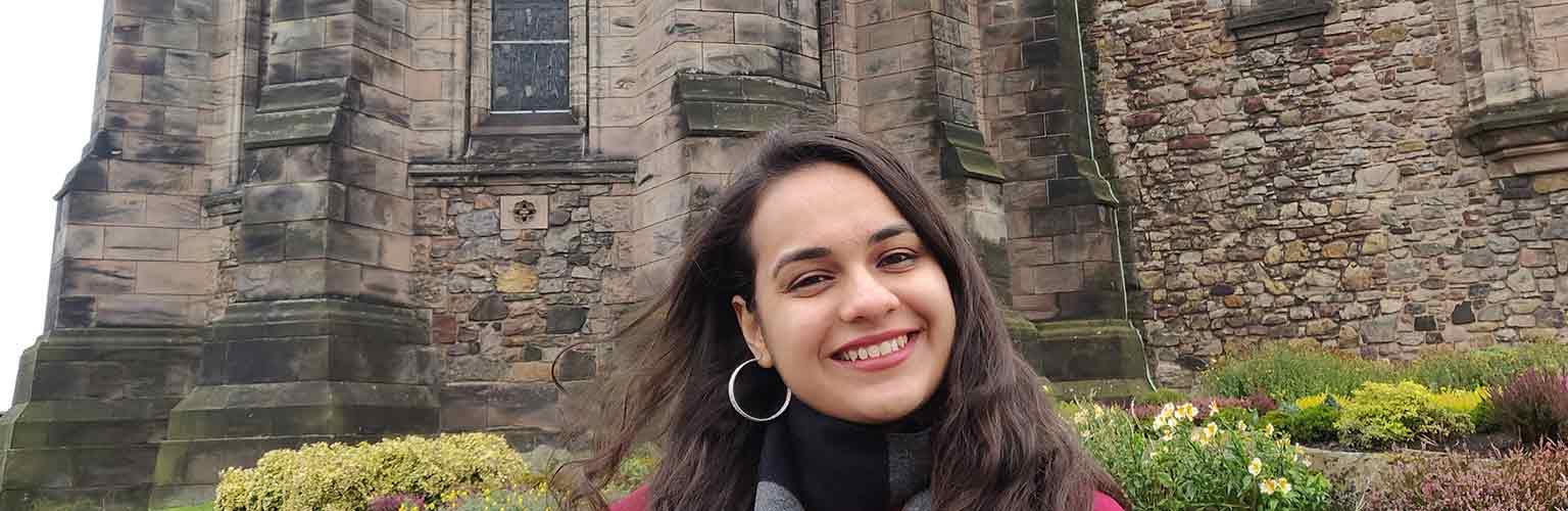 Payal Mehta stood in front of a stone building in Scotland