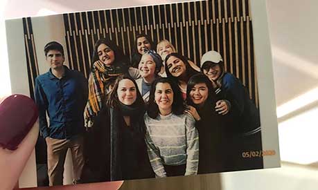 Danielle Wei Ling holding a photo of her and her friends at Alliance Manchester Business School