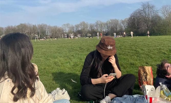 Marcelo and friends sitting down in a park in Manchester