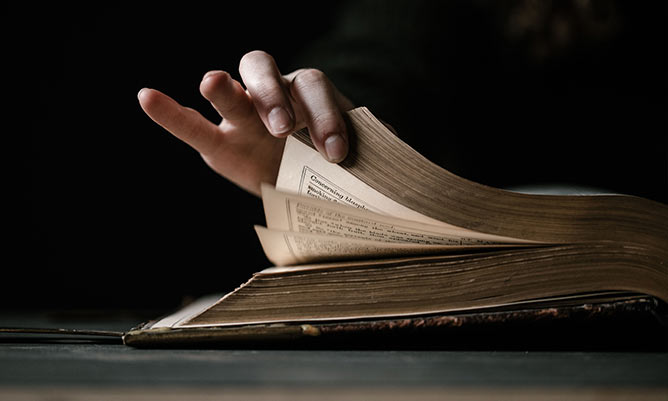 person leafing through a book