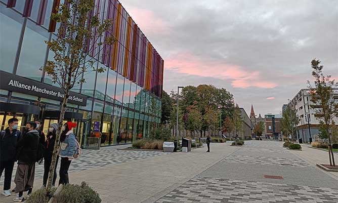 The front of the Alliance Manchester Business School building in the sunset