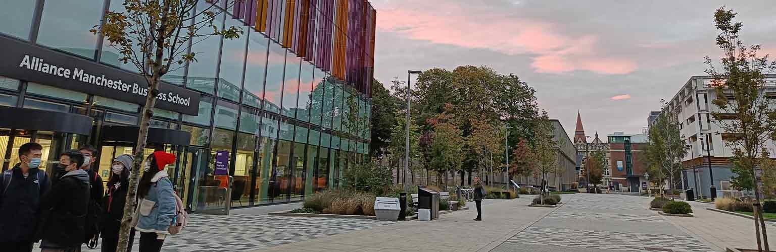 The front of the Alliance Manchester Business School building in the sunset