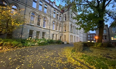 The University of Manchester building with yellow leaves on the road