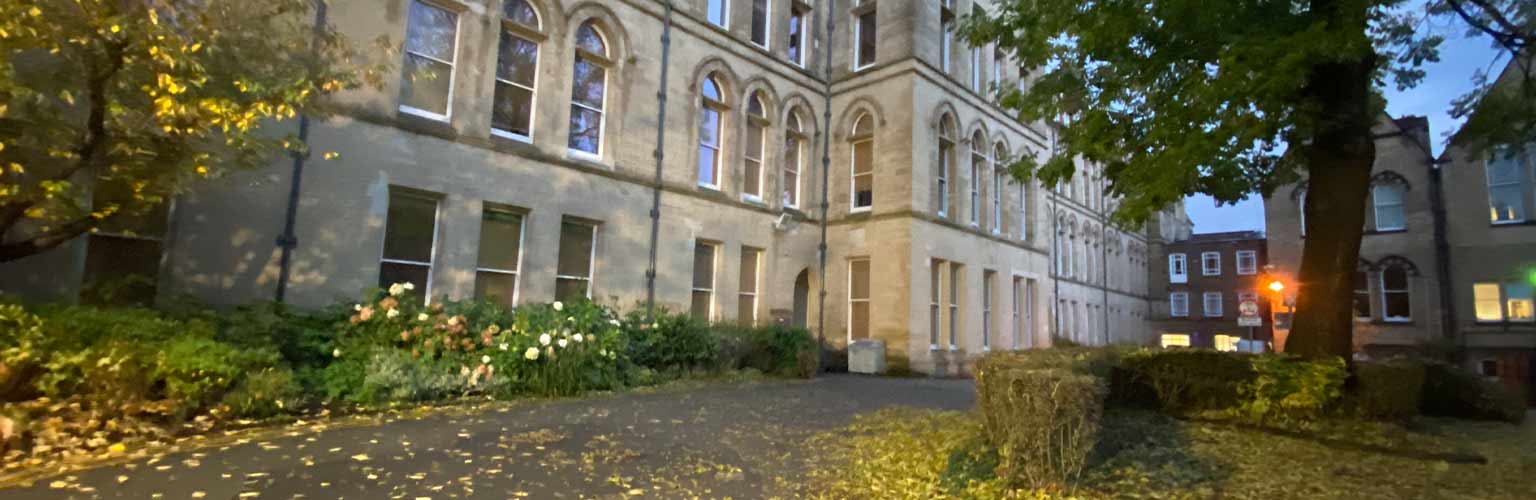 The University of Manchester building with yellow leaves on the road