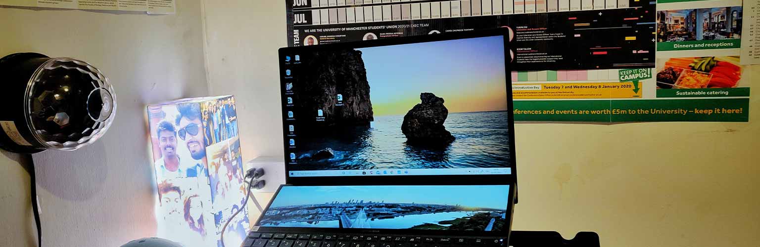 A desk with a laptop on with a calendar in the background