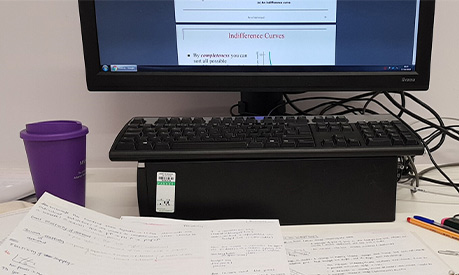 A desk with notes and a computer on