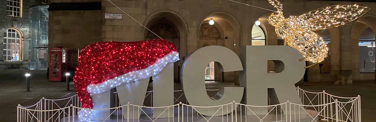 The MCR sign outside Central Library in Manchester with a santa hat on the letter M