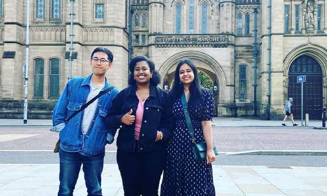 A picture of Michelle and her friends with the University of Manchester arch in the background