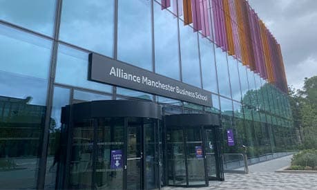 The front of the Alliance Manchester Business School building with grey skies in the background