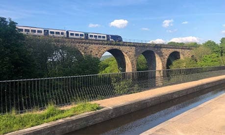 A viaduct with a northern rail train travelling on top of it