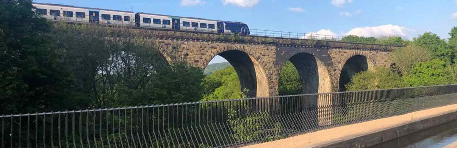 A viaduct with a northern rail train travelling on top of it