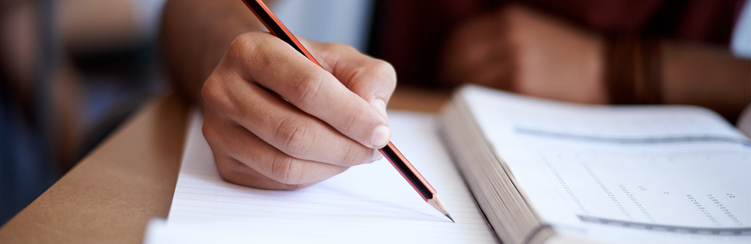 person writing sat at a desk