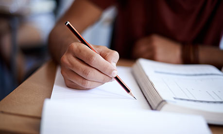 person writing sat at a desk