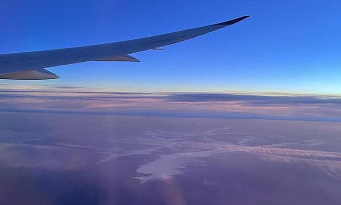 A picture of the wing of a plane from inside the plane