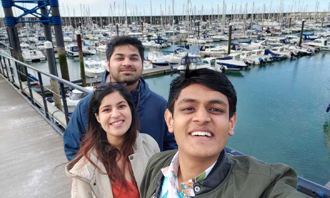 Ashish and his friends by a harbour in the UK