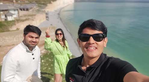 Ashish and his friends by the beach in the UK