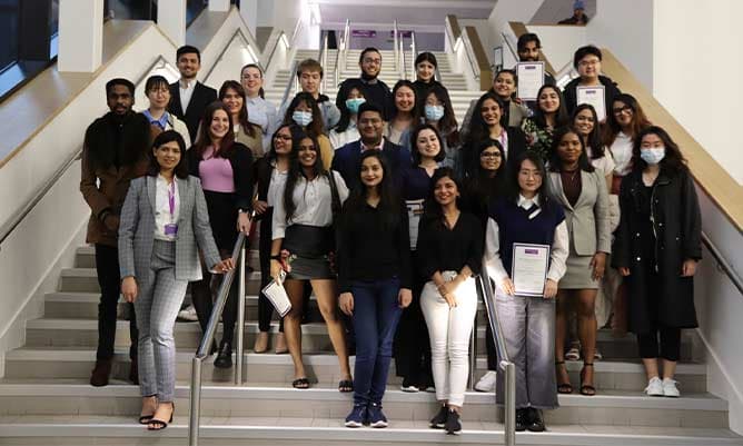 Eleni Chliapa and her course mates at the bottom of the main staircase in the Alliance Manchester Business School building