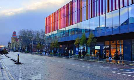 A view of the Alliance Manchester Business School building from Oxford road during overcast conditions