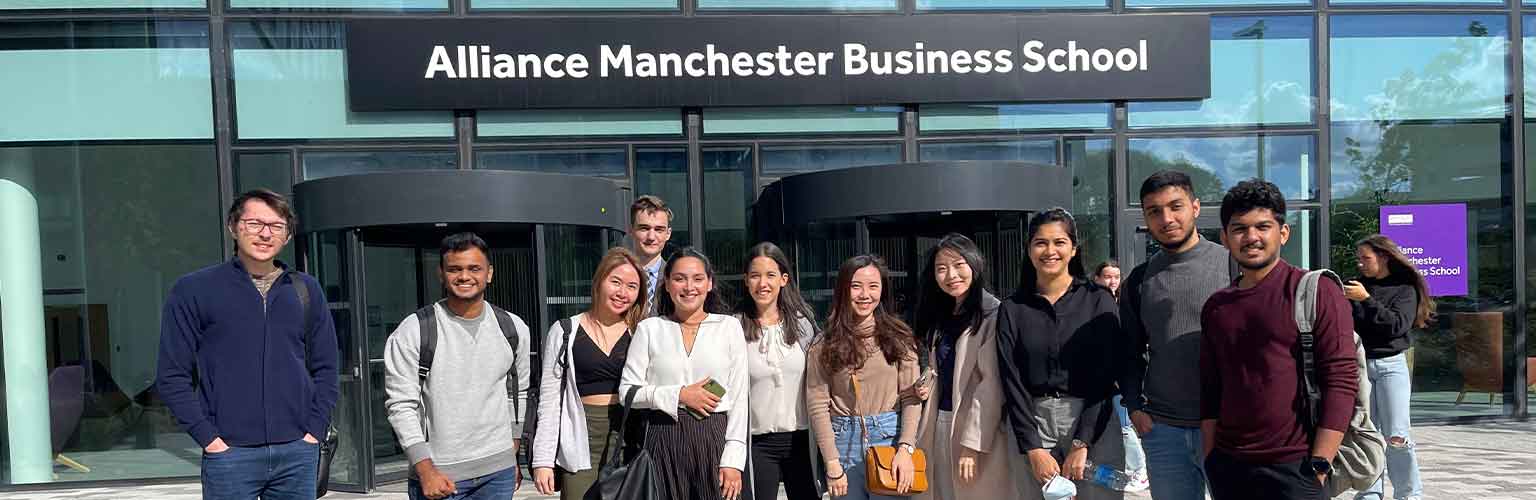 Rishwin Barasia and friends in front of the Alliance Manchester Business School building.