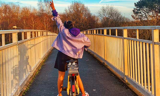 Yuvasri Raghavan on a bike crossing a bridge