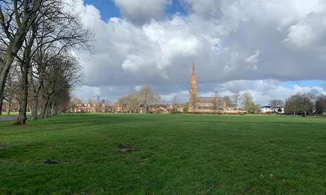 A park in Manchester with blue sky and white cumulus clouds