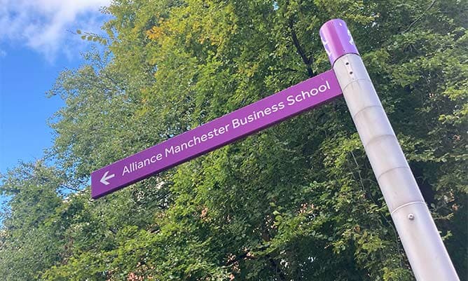 A waypoint sign pointing in the direction of Alliance Manchester Business School
