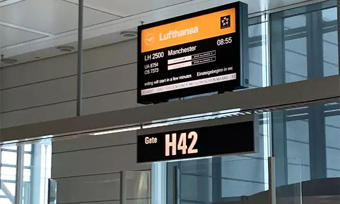 A boarding gate at an airport showing the destination as Manchester