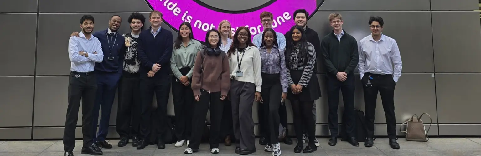 14 young professionals standing outside UBS building.