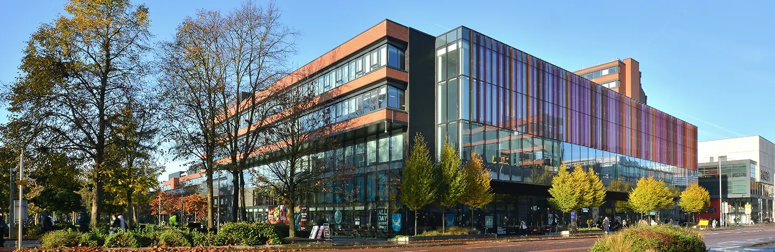 Alliance Manchester Business School building on Oxford Road at the University of Manchester, viewed from the street on a clear day.