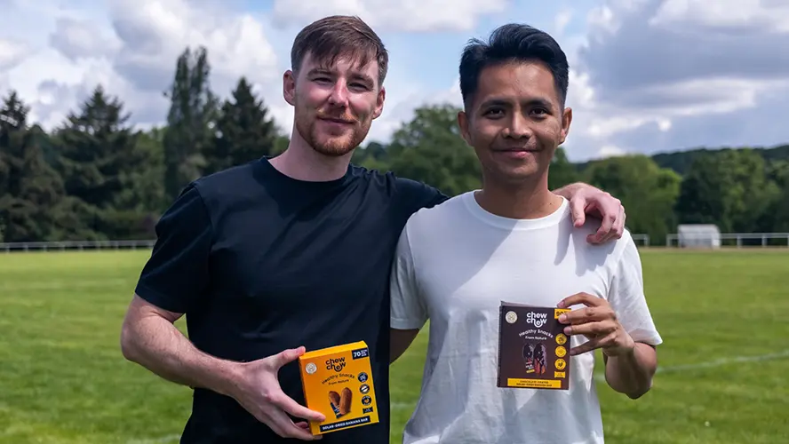 Tom and Aaron standing next to each other both holding Chew Chew products.