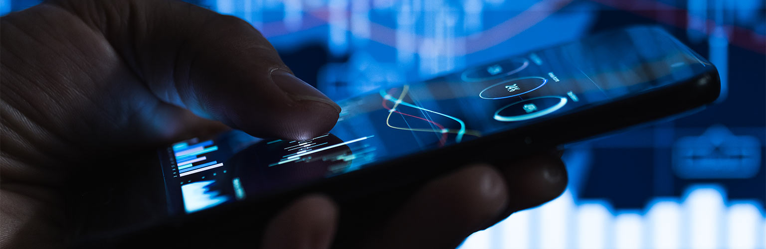 a businessman searching on his smartphone with the stock market in the background