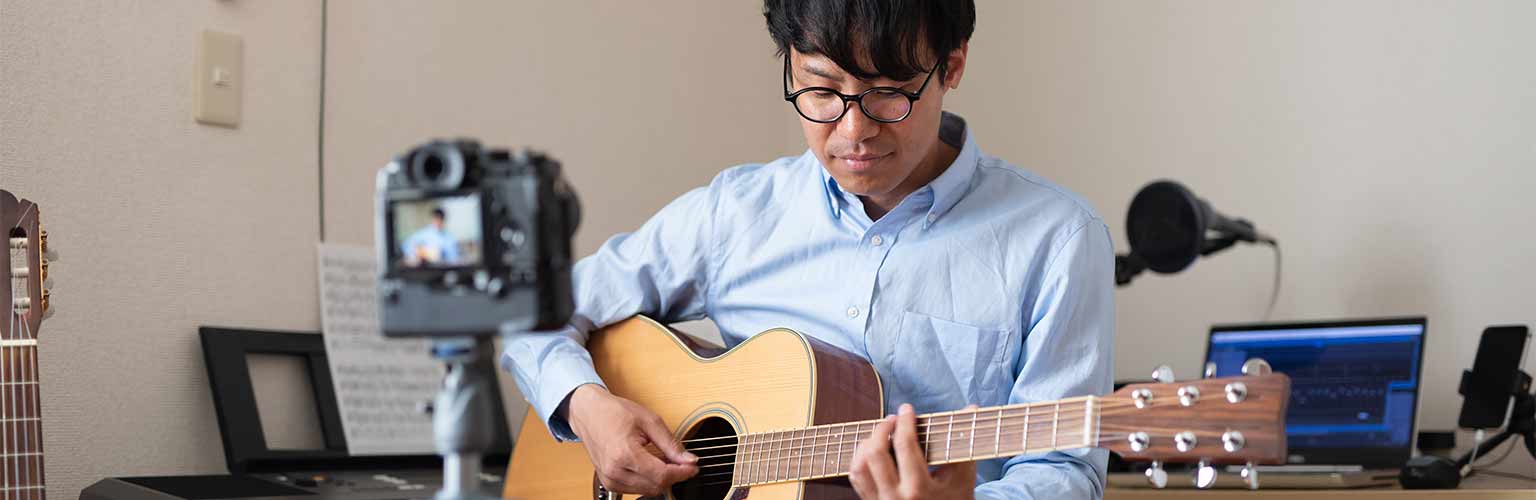 A man recording a song on his guitar