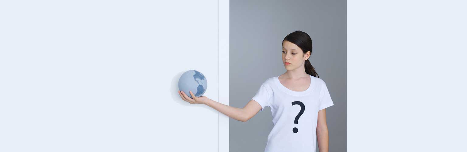 Woman holding globe and wearing t-shirt with question mark on