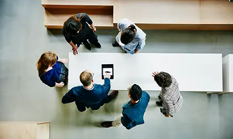 people stood around an office table