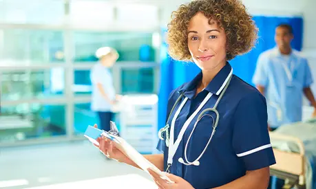 Women in healthcare setting holding a clipboard