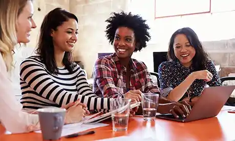 women smiling and talking at work