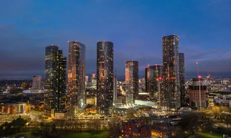 A vibrant cityscape showcasing the illuminated skyscrapers of Manchester at night, emphasizing the urban development and modernity of this iconic UK city.