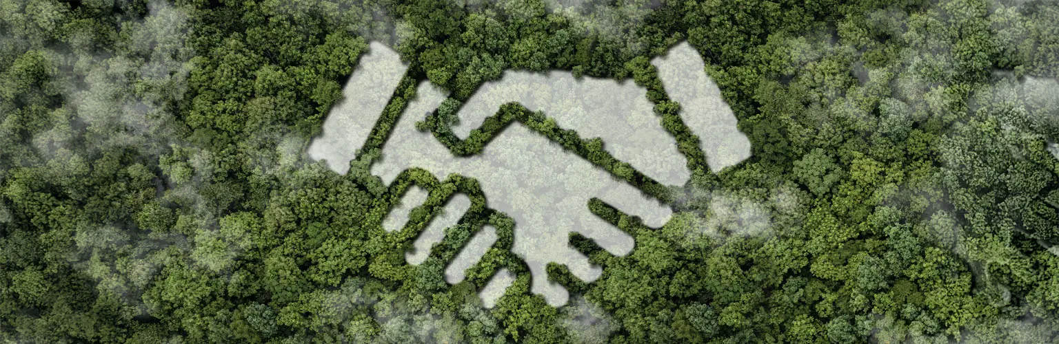 An icon of hands holding over trees.