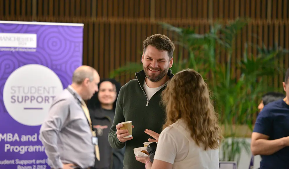 Two delegates talking during a coffee break.