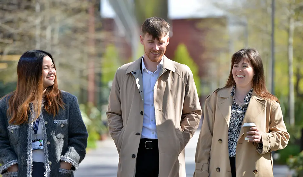 Three MBA students walking together on campus.