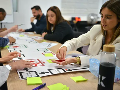 Delegates adding counters to a large brainstorming sheet during a workshop.