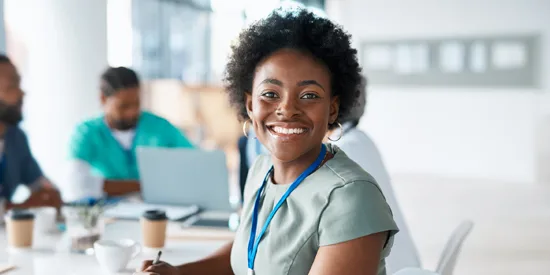 Woman doctor smiling during a meeting with colleagues