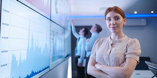 Woman stood in front of a screen with data on it