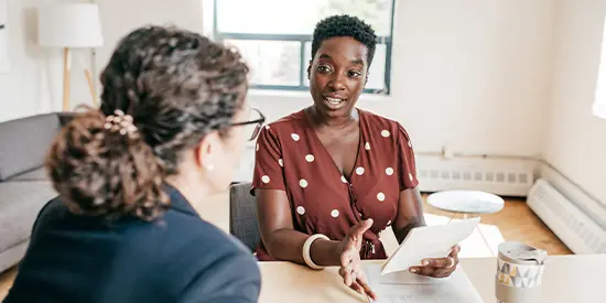 two colleagues sat down opposite one another in a meeting