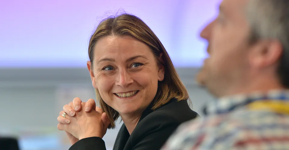 A woman smiles at another student during a leadership course